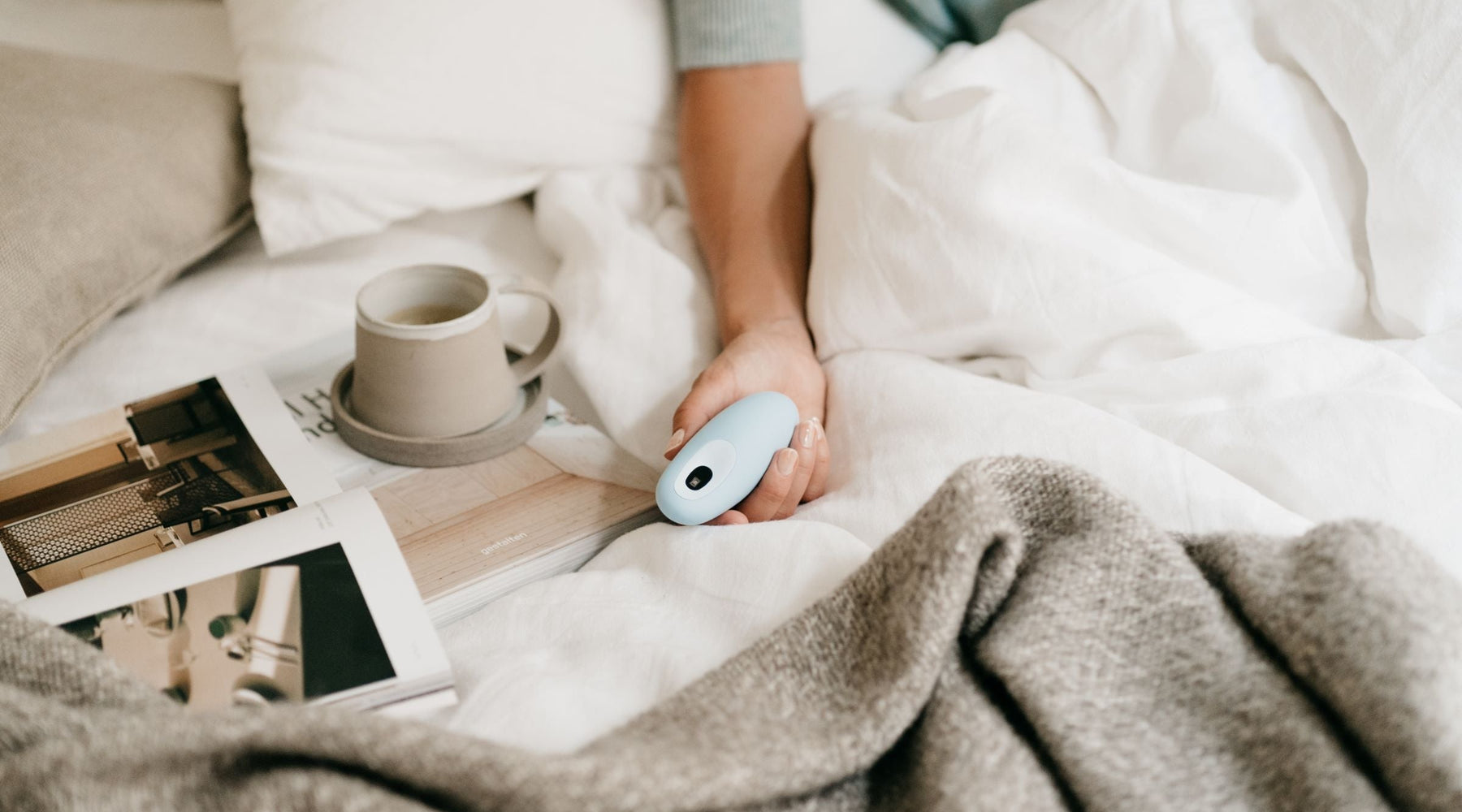Hand holding moonbird in bed.