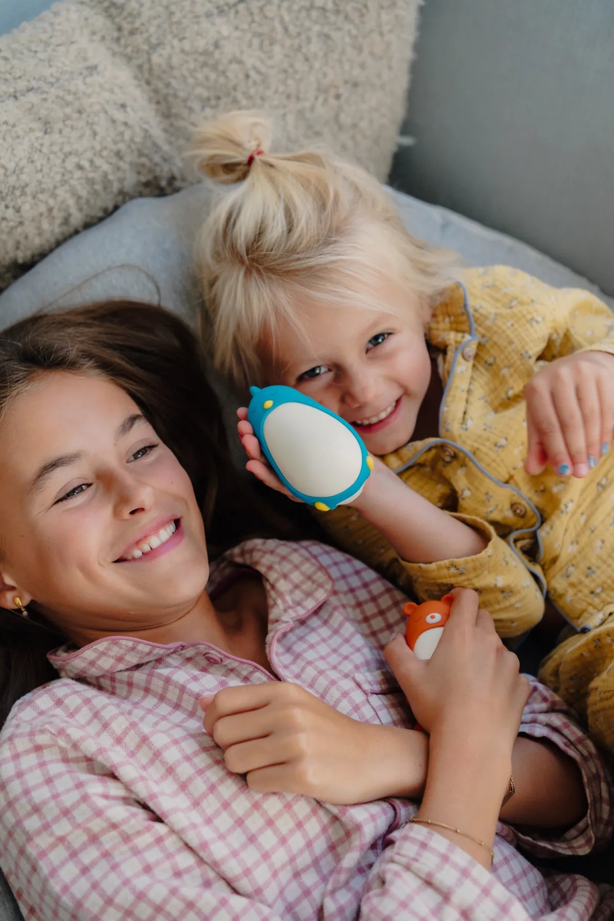 Two sisters in pyjamas laughing with Bibi and Barry moonbuddies