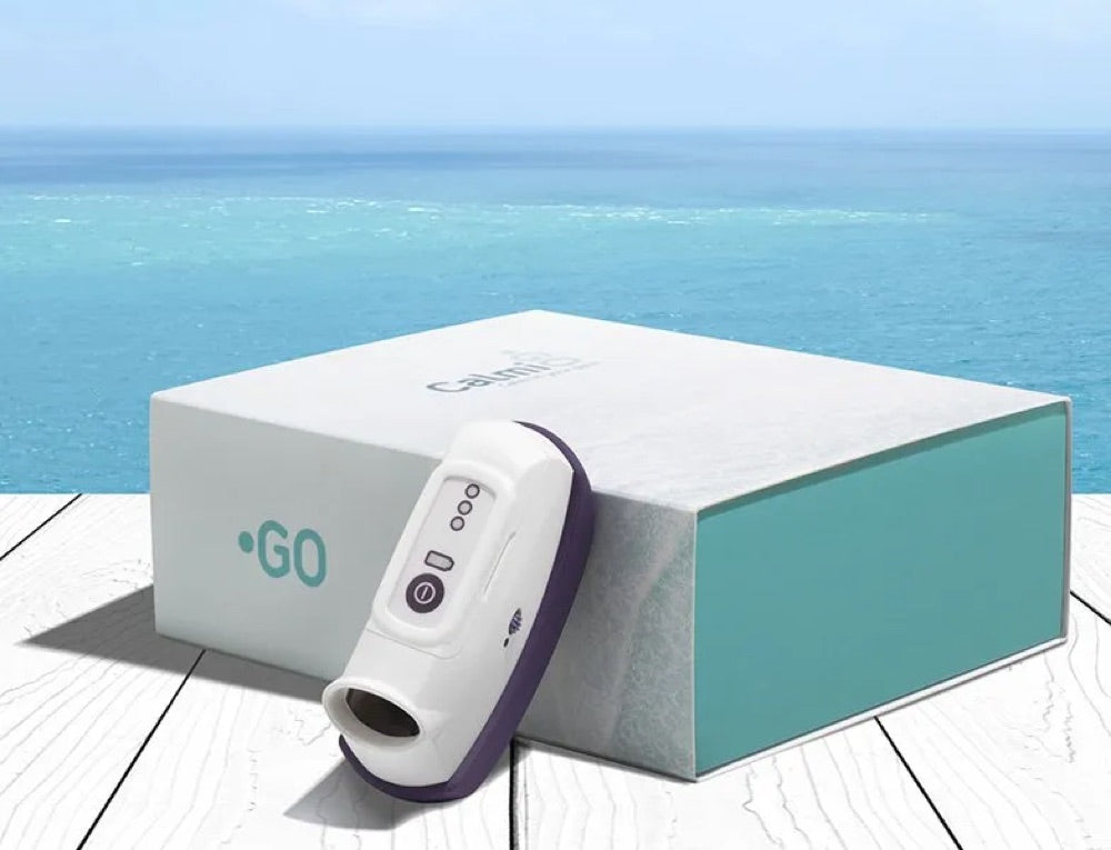 A CalmiGo device leaning against its box